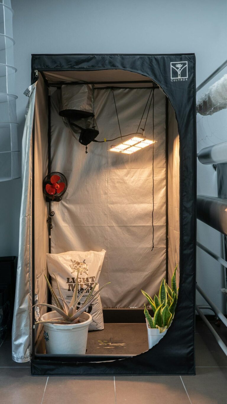 A grow tent with LED lights, fan, and gardening supplies for organic plant cultivation.